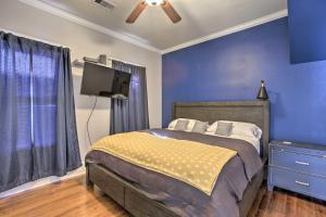 sypialnia z łóżkiem i telewizorem oraz niebieskimi ścianami w obiekcie Cozy Beach Bungalow Near Galveston Seawall and Pier w mieście Galveston