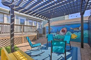 a patio with chairs and a mural on a house at Cozy Beach Bungalow Near Galveston Seawall and Pier in Galveston