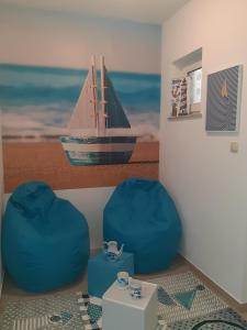 a room with two blue chairs and a boat on the wall at grabrova cove in Novi Vinodolski