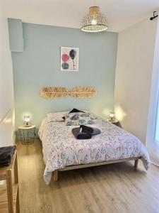 um quarto com uma cama com um edredão em LE DUMON 2 - T2 avec GARAGE - TERRASSE - WiFi - Gare à 200m em Agen