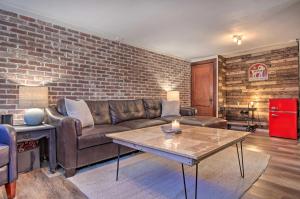 a living room with a couch and a brick wall at Convenient Denver Home with Private Hot Tub! in Denver