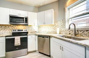 a kitchen with white cabinets and a stainless steel appliance at Warrensburg Home, Close to Downtown! in Warrensburg