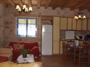 a living room with a refrigerator and a kitchen at Lithos stone house (Ionio holidays) in Vasilikos