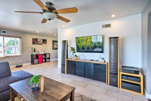 a living room with a couch and a ceiling fan at Sunny Santa Ana Rental Home Near Disneyland! in Santa Ana