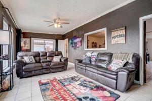 a living room with two leather couches and a rug at Family Home with Sunroom and Fire Pit! in New Braunfels