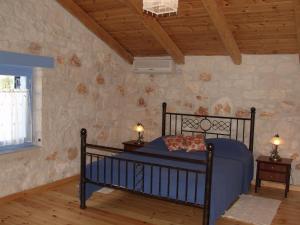 Un pat sau paturi într-o cameră la Lithos stone house (Ionio holidays)