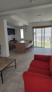 sala de estar con sofá rojo y cocina en Duplex en barrio privado en Mendoza