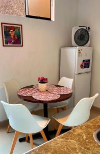 een keuken met een tafel en stoelen en een koelkast bij Lindo dpto con vista al jardin, internet y cable in Lima