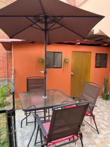 een tafel en stoelen onder een parasol op een patio bij Lindo dpto con vista al jardin, internet y cable in Lima