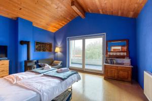 ein blaues Zimmer mit einem Bett und einem Spiegel in der Unterkunft Vila Nadrožica 