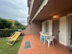 a patio with a table and chairs next to a house at Relax in Piscina - Free Parking e ampio Giardino in Loano