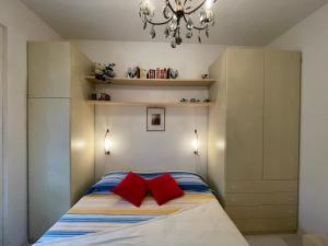 a bedroom with a bed with two red pillows at Relax in Piscina - Free Parking e ampio Giardino in Loano