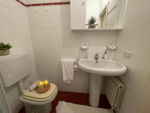 a white bathroom with a toilet and a sink at Relax in Piscina - Free Parking e ampio Giardino in Loano +19 photos