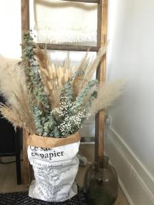 um vaso com um ramo de flores ao lado de uma janela em les chambres de pauline appartements em Albertville