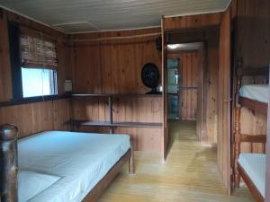 1 dormitorio con 2 camas en una habitación de madera en Chalé do Tibet Vale da Utopia, en Guarda do Embaú