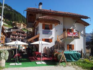 a building with tables and umbrellas in front of it at Chalet Heidi in Arabba