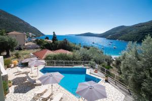 a swimming pool with umbrellas and a view of a lake at Rouda Village in Mikros Gialos