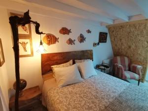 a bedroom with a bed with a lamp and a chair at Chalé da Baía in Porto Covo