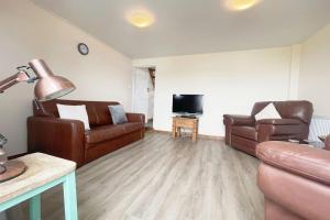 a living room with two couches and a tv at Cheerful Home Short Drive to Beautiful Beach in Redruth