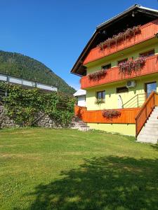 a building with a balcony with flowers on it at Apartmaji Hodak in Bohinj