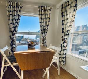 Viewing Room, seaview 30 seconds from beach في برودستيرز: غرفة طعام مع طاولة وكراسي ونافذة