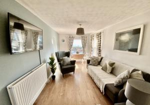 a living room with a couch and a chair at Viewing Room, seaview 30 seconds from beach in Broadstairs