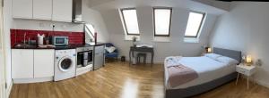 1 dormitorio con 1 cama y cocina con lavadora en Cosy studio flat for students or workers. en Bedford