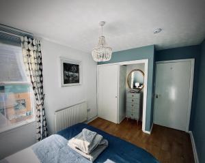 a bedroom with a bed and a mirror and a chandelier at Viewing Room, seaview 30 seconds from beach in Broadstairs