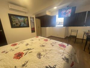 een slaapkamer met een bed met een dekbed met bloemen erop bij 15 Acogedor dpto de un ambiente en miraflores in Lima