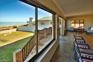 a balcony with chairs and a view of the ocean at Oppi Stuppi Langebaan in Langebaan