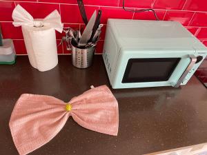 a counter with a pink bow on top of a microwave at Cosy studio flat for students or workers. in Bedford