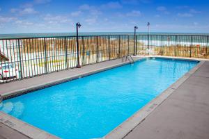 a large blue swimming pool with the ocean in the background at Summer Beach 508 in Ocean City