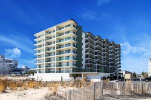 a large apartment building on the beach with a fence at Summer Beach 508 in Ocean City