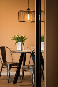 a dining room table with chairs and a potted plant at Uniejów Apartments in Uniejow