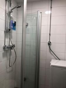 een badkamer met een douche en een glazen deur bij Stylish spacious studio near centre by the sea in Helsinki