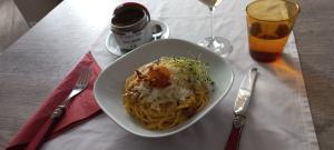 a plate of pasta on a table with a drink at Nuova Locanda Turisti in Bignasco