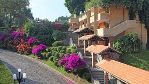a building with a garden of purple flowers and bushes at Marriott Puebla Hotel Meson del Angel in Puebla