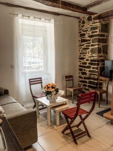 a living room with a couch and a table and chairs at LA MAISON DU PORT in Plérin