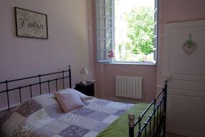 a bedroom with a bed with a quilt and a window at Gîtes du château de la Motte in Joué-du-Plain