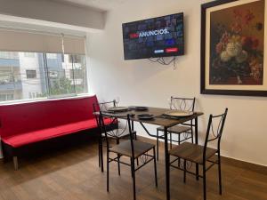 a dining room with a red couch and a table and chairs at 14 Departamento acogedor y nuevo en Miraflores in Lima