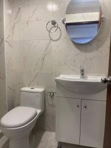 a bathroom with a toilet and a sink and a mirror at 14 Departamento acogedor y nuevo en Miraflores in Lima