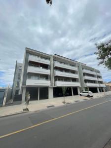 um grande edifício numa rua com um carro estacionado em frente em Amplio y lujoso departamento em Mendoza