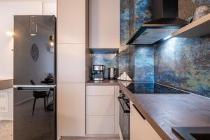 a kitchen with white cabinets and a stainless steel refrigerator at Emirates Lux Apartment and Parking in Sofia