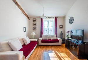 ein Wohnzimmer mit einem Sofa und einem TV in der Unterkunft Samourai Massena Lodge -1 min from the sea in Nizza