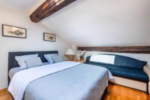 ein Schlafzimmer mit einem großen weißen Bett mit blauen Kissen in der Unterkunft Samourai Massena Lodge -1 min from the sea in Nizza