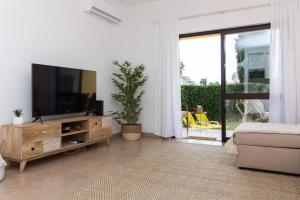 un salon avec une télévision à écran plat et un canapé dans l'établissement Oura 7, à Albufeira