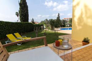 a patio with chairs and a table and a pool at Oura 7 in Albufeira