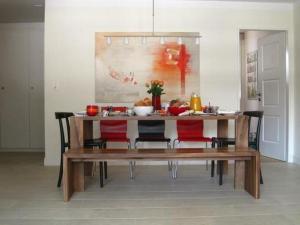 una mesa de comedor con sillas rojas y una pintura en Modernes, exklusives Apartment im Dorf am Davoser See, Skikeller, Innenpool, Sauna, Balkon, en Davos