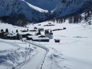 una montaña cubierta de nieve con un pueblo y una carretera en Modernes, exklusives Apartment im Dorf am Davoser See, Skikeller, Innenpool, Sauna, Balkon, en Davos