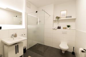a white bathroom with a toilet and a sink at DWELLSTAY - Modernes Apartment I 55qm I 2 Zimmer I Küche I Bad I Terrasse I TV I Netflix in Bad Hersfeld